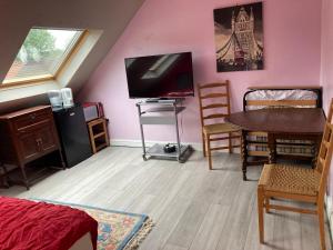 sala de estar con TV, mesa y sillas en Jacks Court B1 en Stalybridge