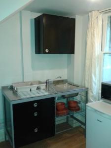 a kitchen with a sink and a microwave at Broadstairs Terrace: Central Broadstairs Flat in Broadstairs