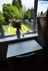 Double guest room في Sedgley: مزهرية من الزهور تقف على حافة النافذة