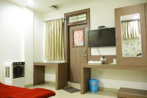 a room with a television and a door with a window at Hotel Neelkanth , Bhopal in Bhopal