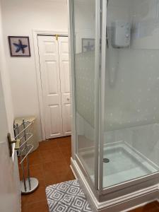 a shower with a glass door in a bathroom at Broadstairs Terrace: Central Broadstairs Flat in Broadstairs