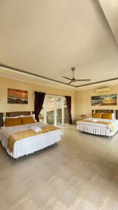 two beds in a large room with windows at The Hawk's Nest Resort in Sabong