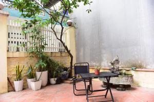 a patio with a table and chairs and plants at HeHe Homestay Hanoi in Hanoi