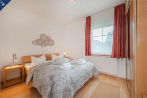1 dormitorio con cama y ventana en Lütow Ferienhaus an der Südspitze Gnitz, en Lütow
