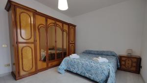 a bedroom with a bed and a large wooden cabinet at La Tana della Volpe in Tempera