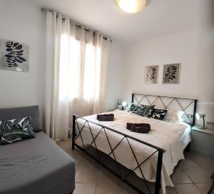 a bedroom with a bed and a couch and a window at Apartment M&J - Valledoria - LA Muddizza - Free WI-FI in Valledoria