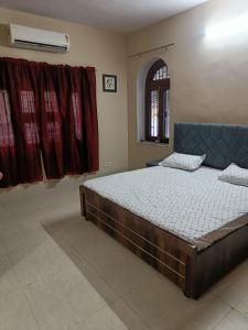 um quarto com uma cama grande e uma janela em Div's luxurious homestay em Jaipur