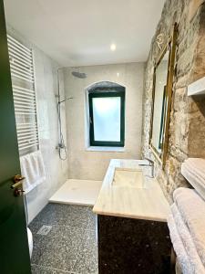 a bathroom with a sink and a shower with a window at Waterfall Kataraktis Vatatsi 