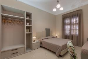 a bedroom with a bed and a dresser and a window at Ghibli Hotel in San Vito lo Capo