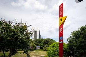 a red and yellow sign on a pole in a park at Livetour Hotel Kehui Golden Valley Guanzhou in Guangzhou