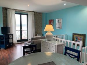 sala de estar con mesa y sofá en Apartamentos Rincón del Puerto, en San Vicente de la Barquera