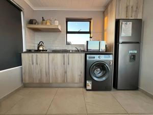 eine Küche mit einem Kühlschrank und einer Waschmaschine in der Unterkunft Seeswael Strand in Velddrif