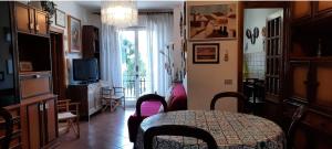 una sala de estar con mesa y TV y una habitación con mesa en Casa Giammarí, en Porto Recanati