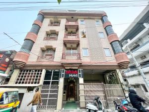 a building on a city street with people walking in front of it at Hotel SHIVAM ! Varanasi Forɘigner's Choice ! fully-Air-Conditioned-hotel lift-and-Parking-availability, near Kashi Vishwanath Temple, and Ganga ghat 2 in Varanasi