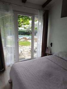 Un dormitorio con una cama y una puerta corrediza de vidrio. en B&B Chambre indépendante double, en Deaux