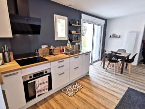 a kitchen with a sink and a stove top oven at Entre mer et foret 1 in Jard-sur-Mer +8 photos
