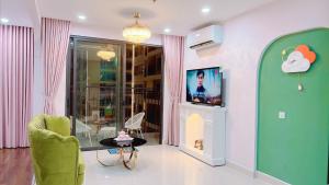een woonkamer met een tv en een stoel en een tafel bij Homestay Vinhomes Ocean Park in Gia Lâm Pho