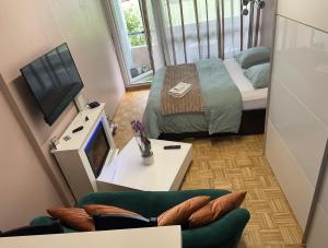 um pequeno quarto com uma cama e um sofá em Chambre Confortable disponible à Genève em Genebra