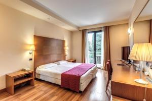 オレッジョ・カステッロにあるLuna Hotel Motel Lago Maggiore Aronaのベッドと大きな窓が備わるホテルルームです。