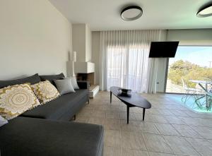 a living room with a couch and a table at RVG Jenny House with pool in Porto Heli