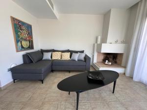 a living room with a couch and a table at RVG Jenny House with pool in Porto Heli
