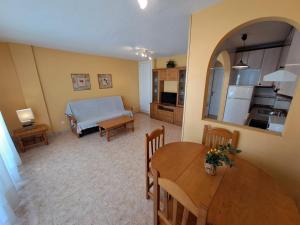 a living room with a table and a kitchen at Apartamentos Marinesco V.v. in La Manga del Mar Menor