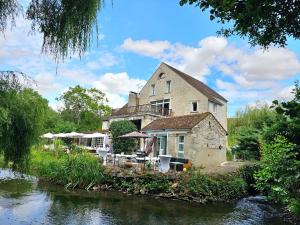 a building on the side of a river at Les Amis du Moulin 