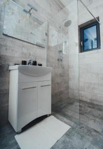 a bathroom with a white sink and a shower at Fanarele din Hangu in Hangul