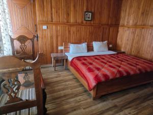 a bedroom with a bed and a wooden wall at Royal Dutch Resorts and Doll Museum in Mukteswar