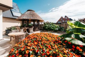 un giardino con gazebo e un mazzo di fiori di Hotel Luina Beach a Büsum