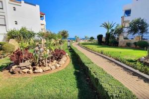 a walkway in a park next to a building at Luxe en bord de mère in Restinga Smir