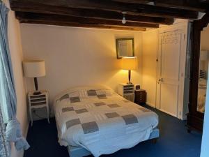 a bedroom with a bed and two lamps on two tables at Les Amis du Moulin 