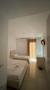 a hotel room with two beds and a window at Hotel Skura in Librazhd