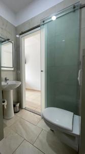 a bathroom with a shower and a toilet and a sink at Hotel Skura in Librazhd