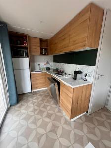 - une cuisine avec des placards en bois et un réfrigérateur blanc dans l'établissement Mobile-home tout équipé avec Jacuzzi, à Porto-Vecchio
