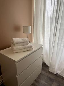 - une commode blanche avec des serviettes dans l'établissement La Maison d Elodie, à Vierzon