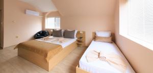 2 łóżka w małym pokoju z oknem w obiekcie Hotel Angy w Złotych Piaskach