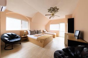 ein Schlafzimmer mit einem Bett und einem Stuhl in einem Zimmer in der Unterkunft Hotel Angy in Goldstrand
