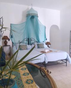 1 dormitorio con 1 cama con dosel azul en L' Ecrin de Mogador Essaouira, en Ounara