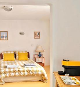 1 dormitorio con 1 cama con almohadas amarillas y TV en Maison Notre Dame des Apôtres en Capbreton