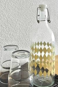 a glass bottle and two glass jars on a table at Maison Notre Dame des Apôtres in Capbreton