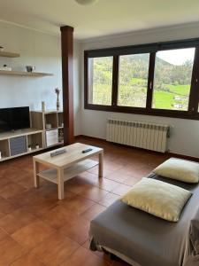 a living room with two beds and a coffee table at Apartamentos La Peral in La Peral