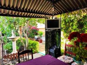 een patio met een tafel en een televisie op een pergola bij Доли in Pomorie