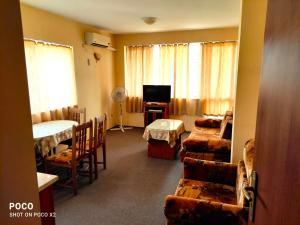 een kamer met een woonkamer met een bank en een televisie bij Доли in Pomorie