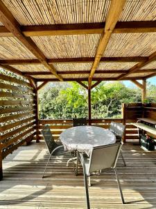 un patio avec une table et des chaises sous un toit en bois dans l'établissement Mobile-home tout équipé avec Jacuzzi, à Porto-Vecchio