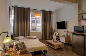 Una sala de estar con una cama y un televisor. en City Lights Preveza, en Preveza