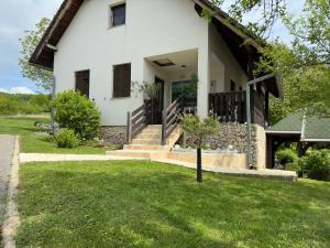 a white house with stairs and a grass yard at Guest House Štefanija in Poljanak