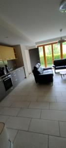 a living room with a couch and a kitchen at Studio de vacances in Crémines