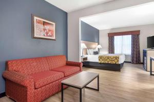 ein Wohnzimmer mit einem Sofa und einem Bett in der Unterkunft Baymont by Wyndham Kennesaw in Kennesaw