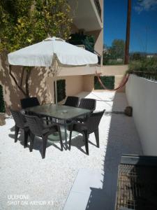 a table and chairs with an umbrella on a patio at Venice Apartments in Limenaria